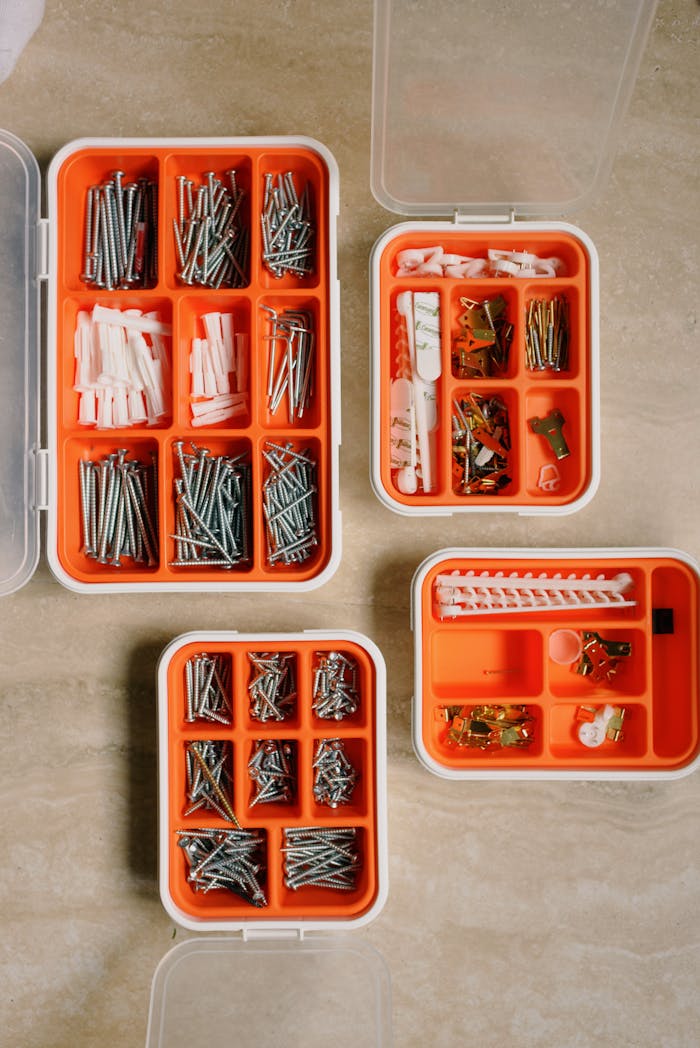 Top view of organized kits containing screws, nails, and fasteners for home repair.